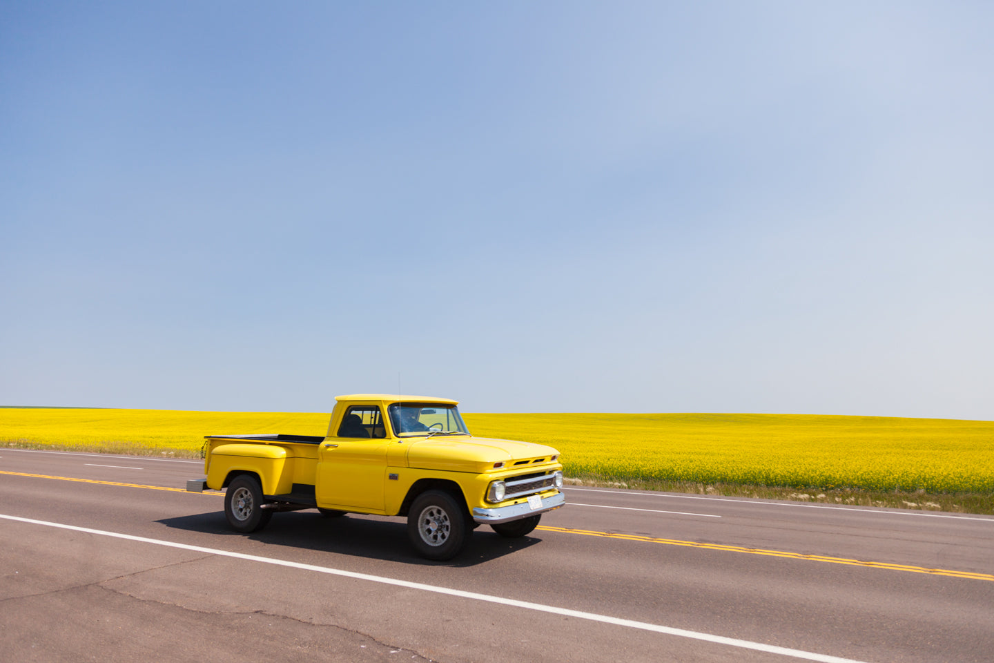 Canola and the Cruiser fine art photography print featuring Drumheller Alberta landscape